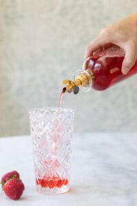 adding strawberry syrup to an Italian Soda