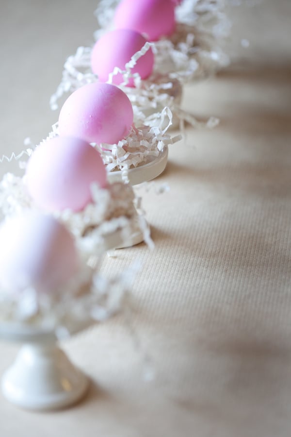 Ombre Easter eggs on mini cake stands with crinkle paper.