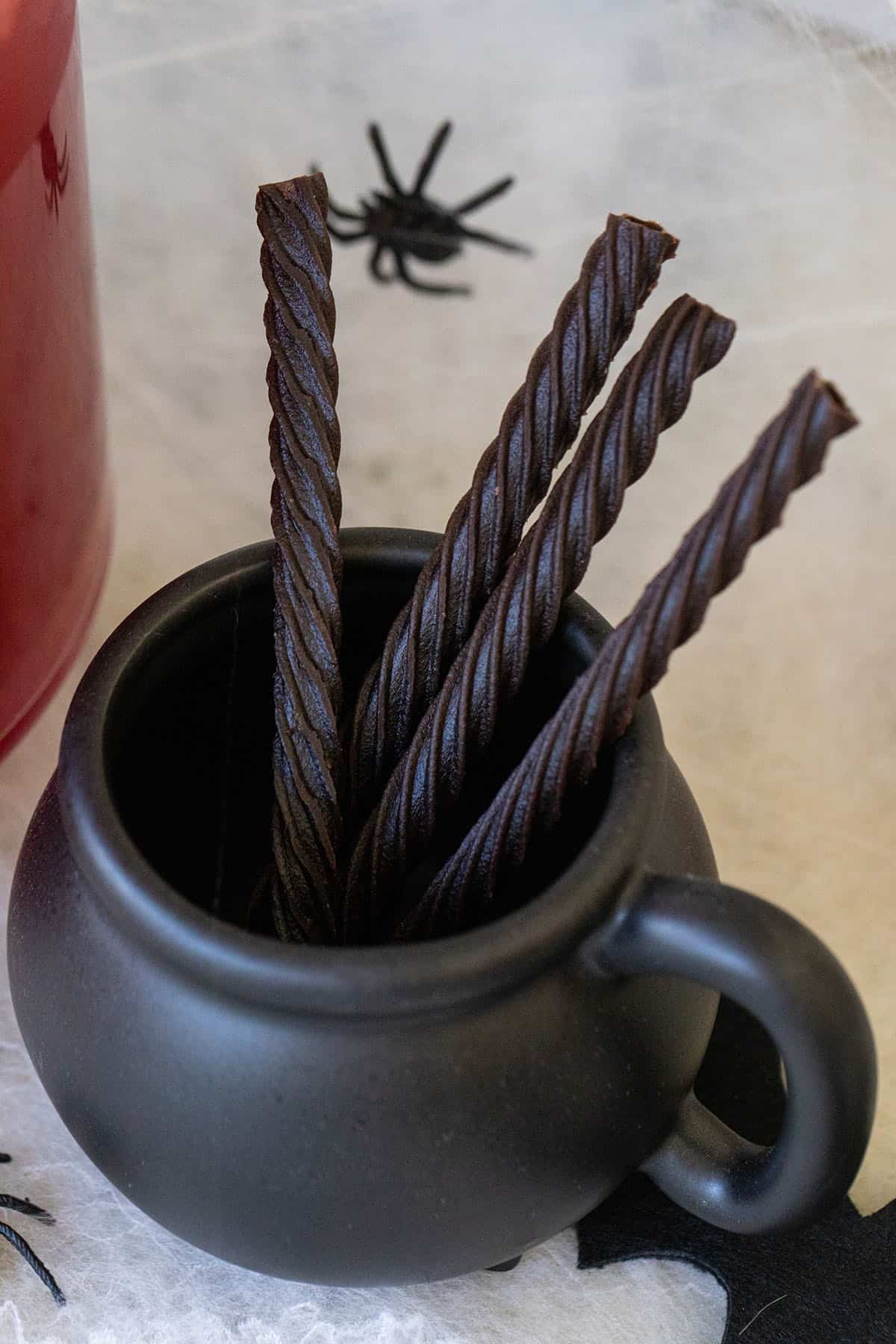 candy straws in a small cauldron.