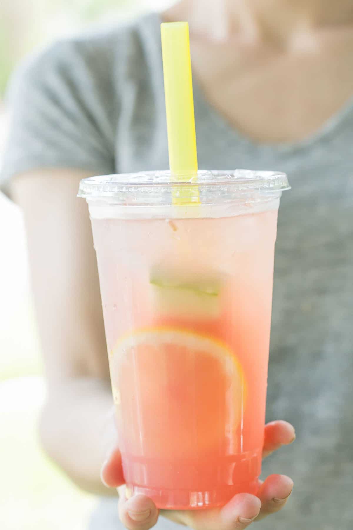 holding a cup filled with watermelon lemonade  - watermelon lemonade, lemon juice, fresh mint, fresh watermelon lemonade, seedless watermelon, sweet tart, fine mesh strainer