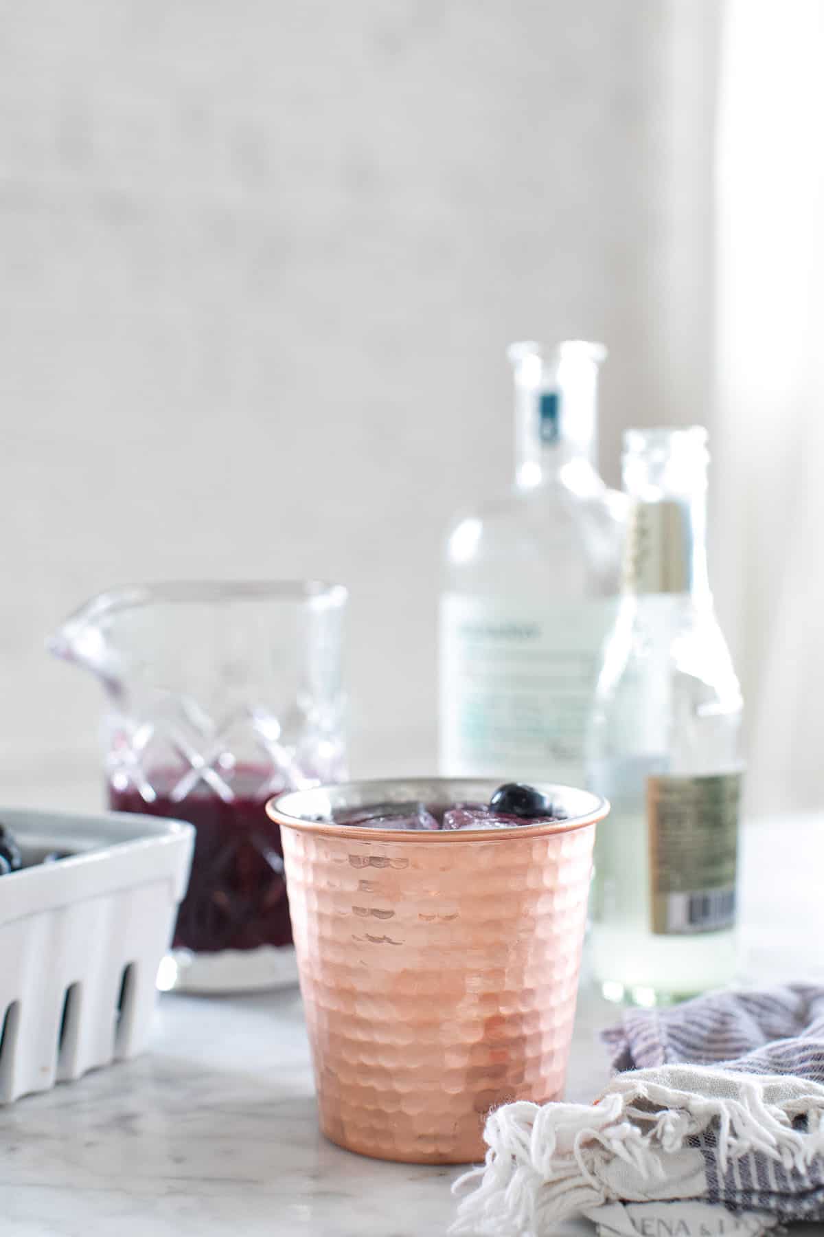 Copper cup with a blueberry mule recipe, ginger beer and fresh blueberries.