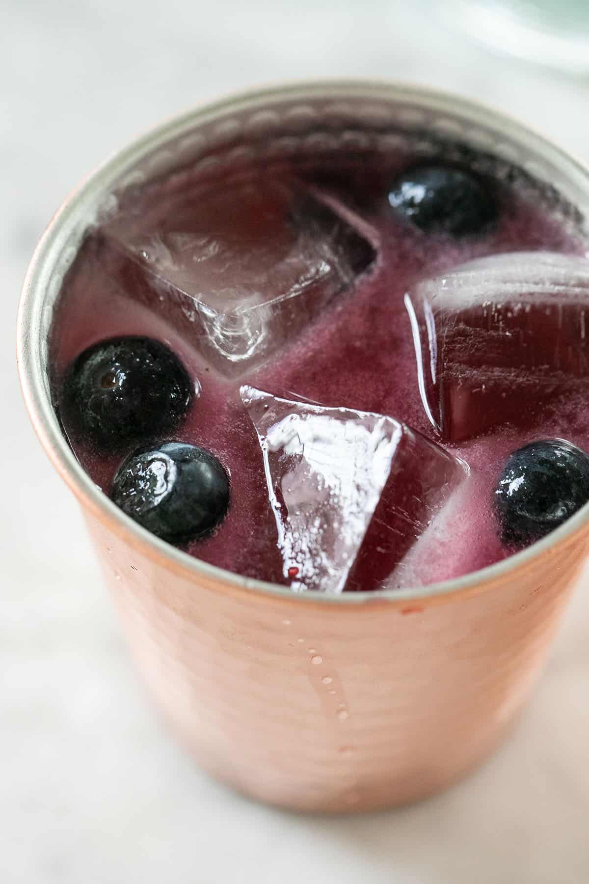 Blueberry Moscow mule with ice and fresh blueberries.  