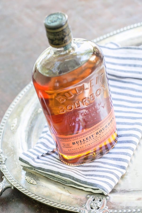 Bottle of Bullet Bourbon on a striped blue napkin.