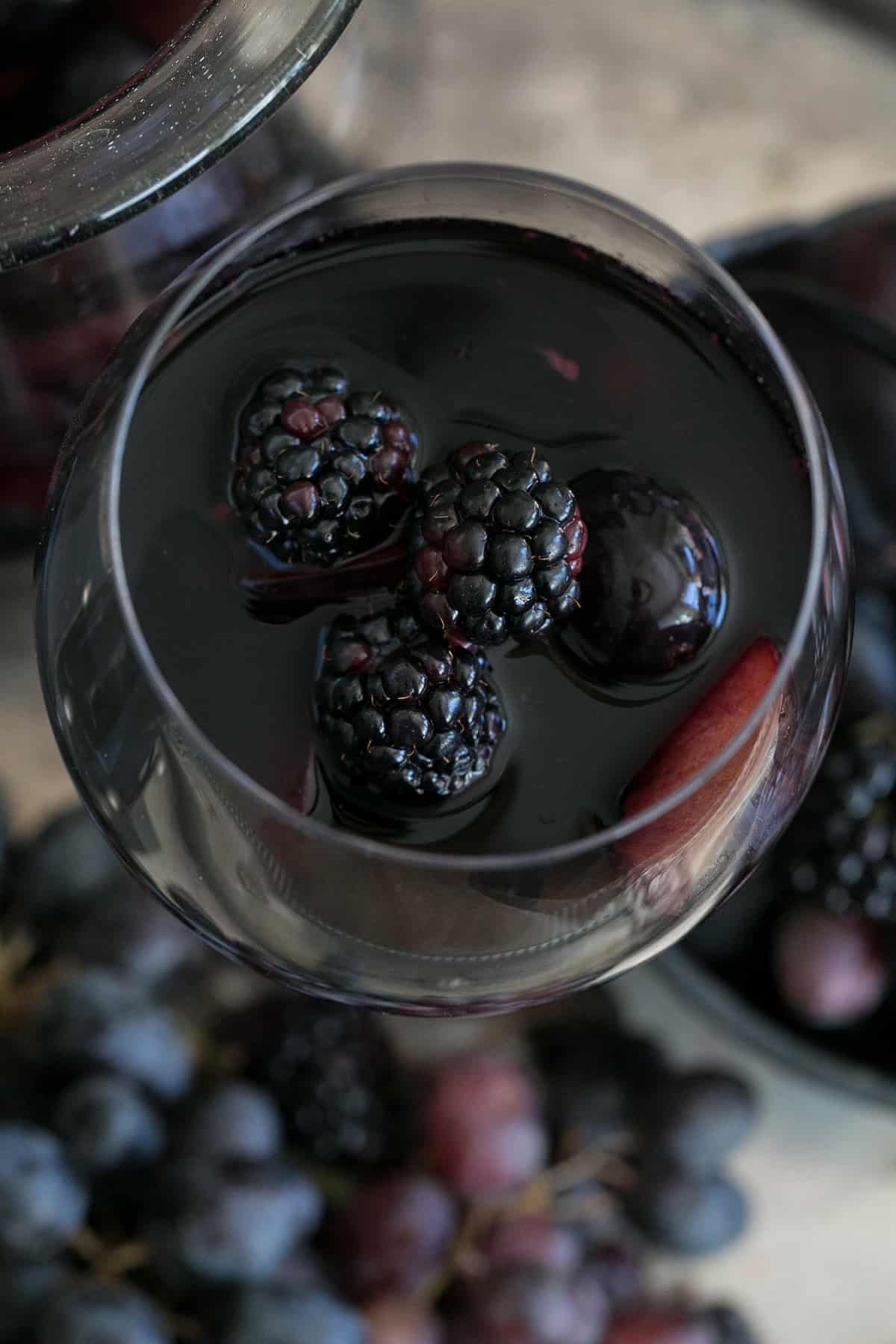 black sangria with blackberries in a wine glass.