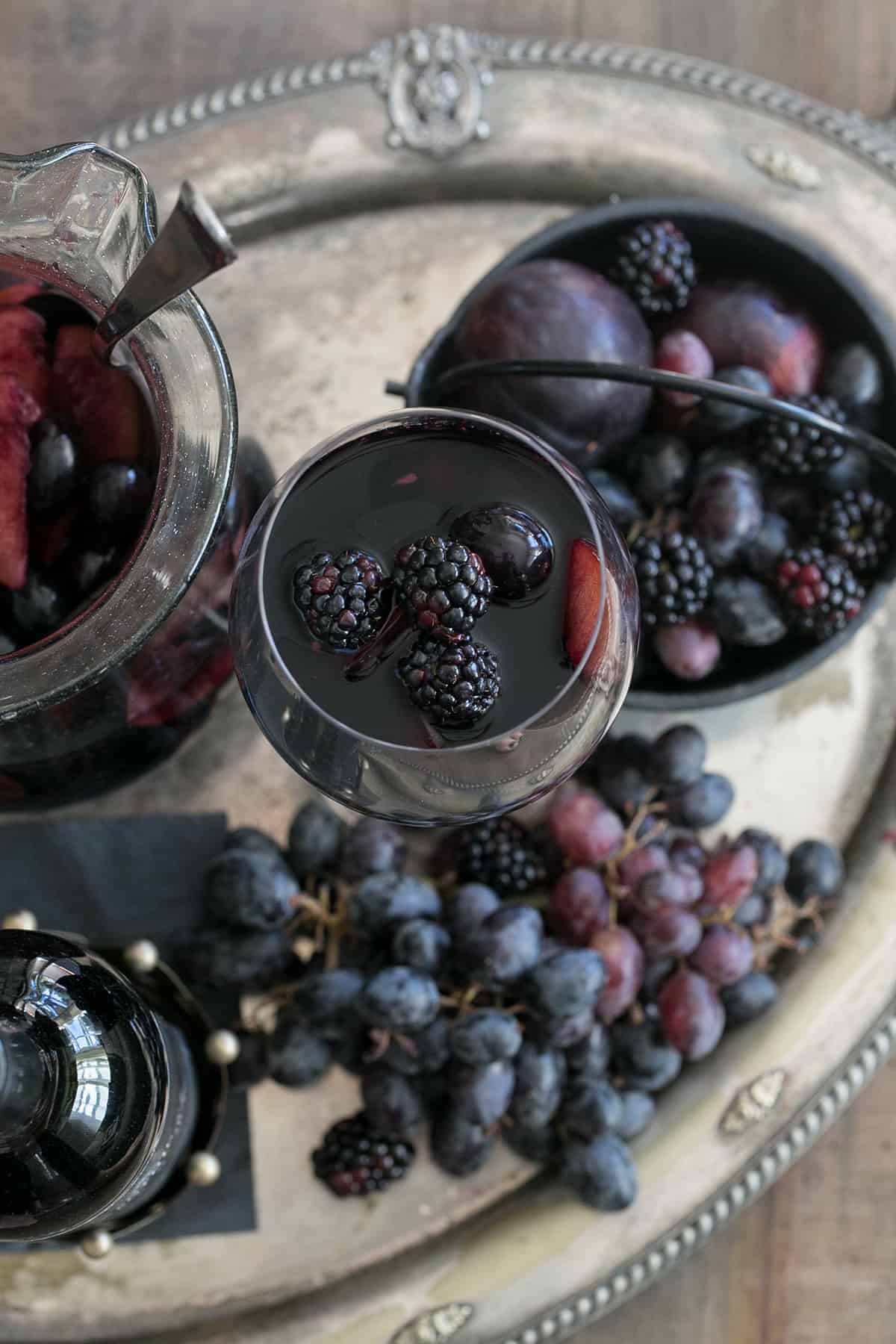 Halloween sangria on a platter with black grapes.