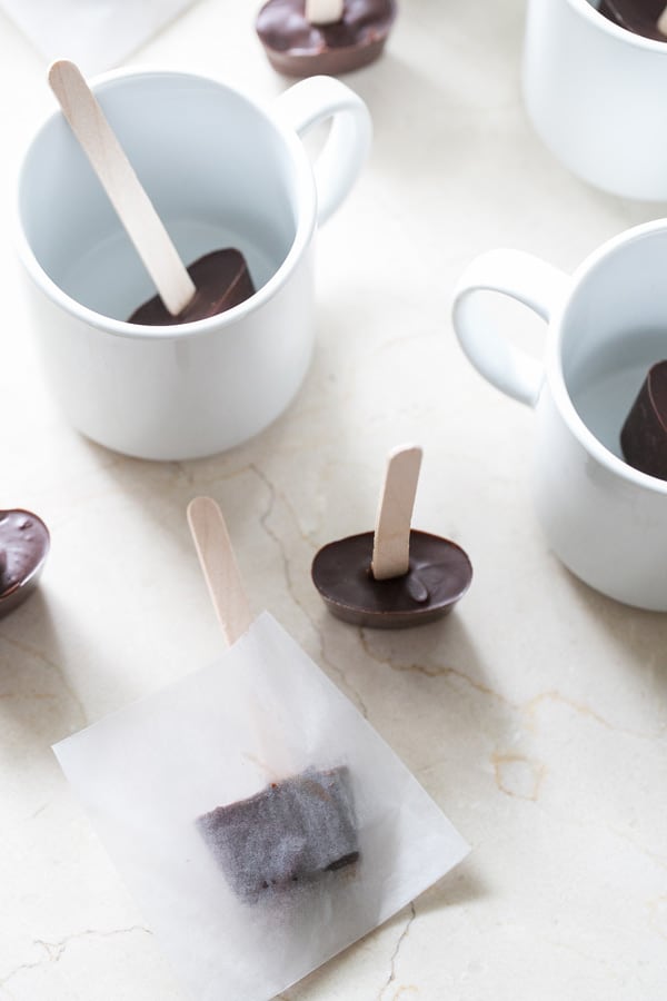 hot chocolate on a stick, surrounded by mugs