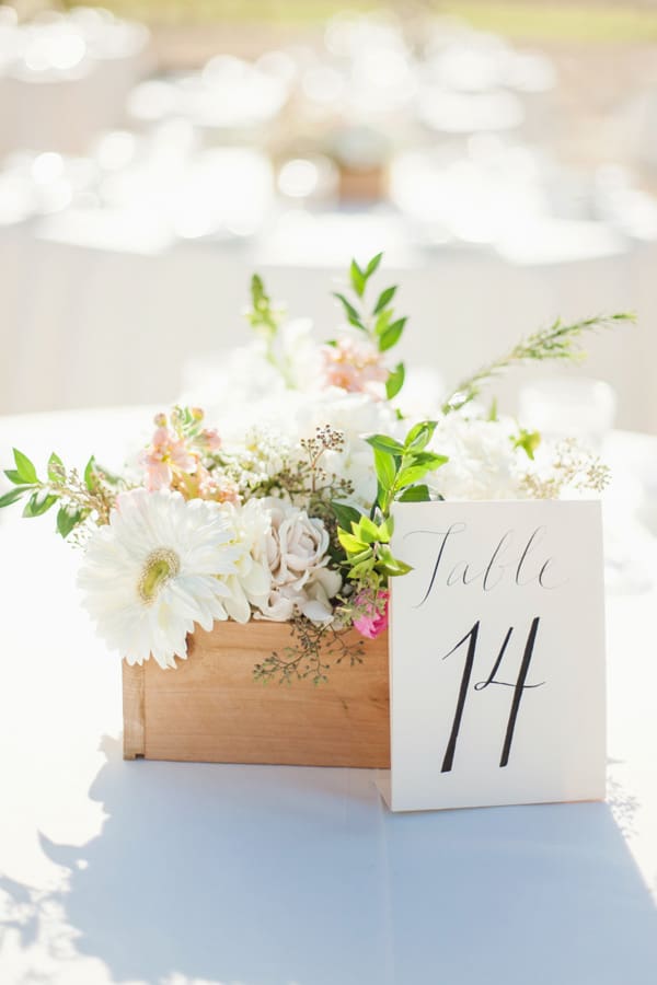 DIY wedding flowers in a wooden box with a table number.