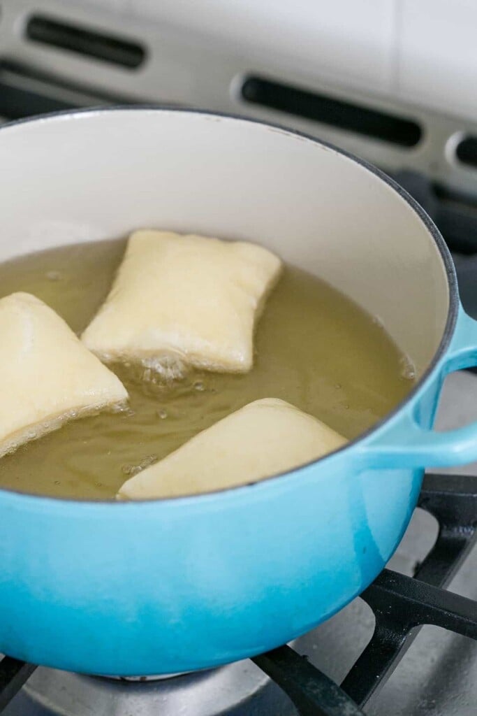 Frying beignets in oil.