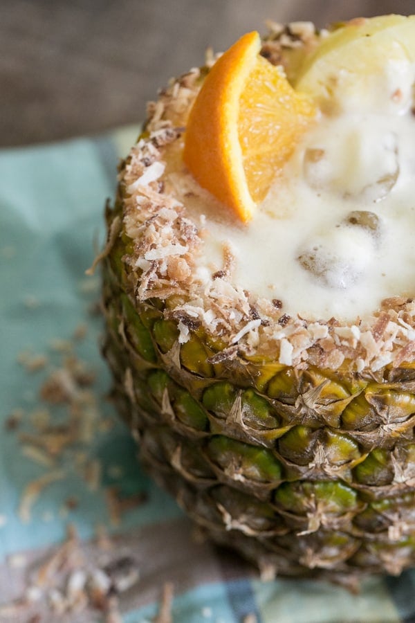 Close up of pineapple rim with toasted coconut and a pineapple rum cocktail inside. 