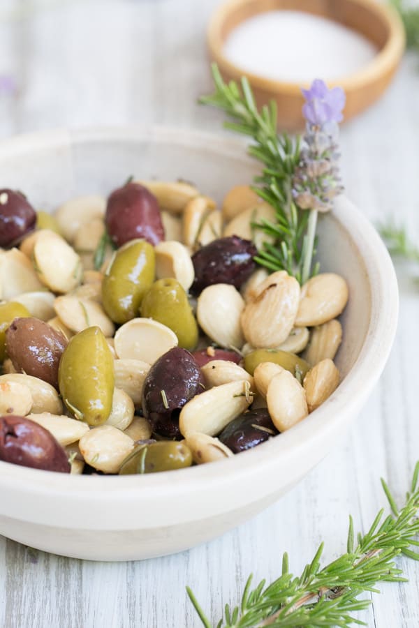 Marcona Almonds with olives, rosemary and lavender in a small bowl.