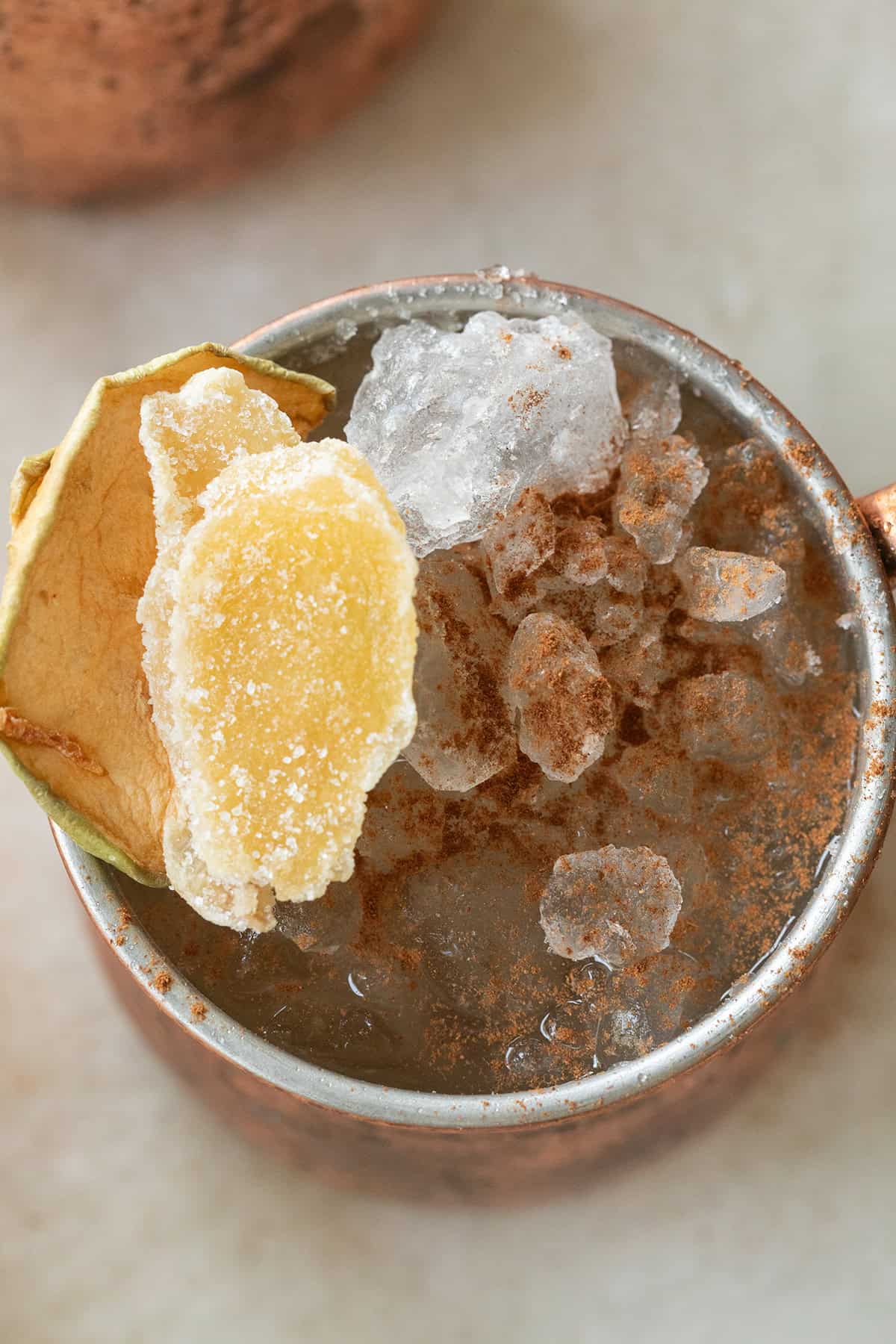 Apple cider Moscow mule with cinnamon over the top and candied ginger.