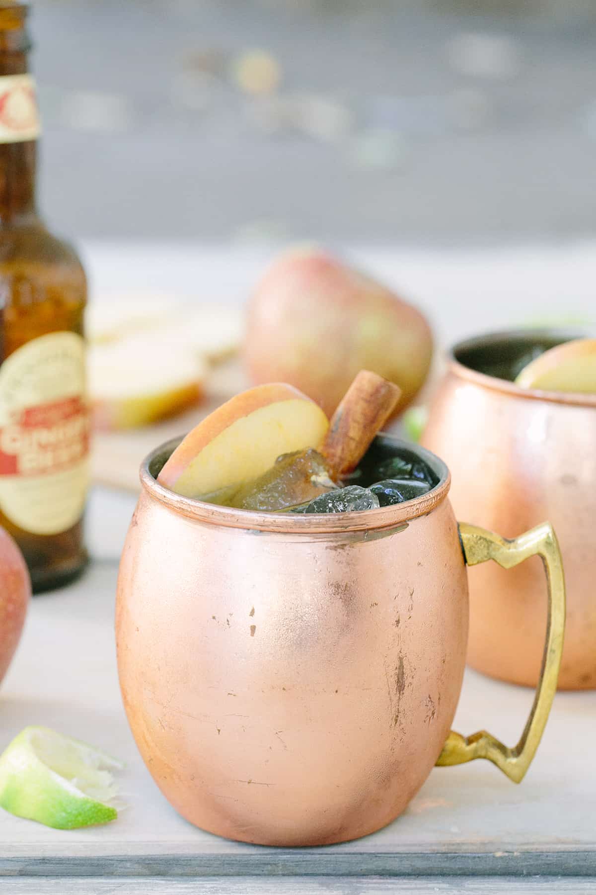 moscow mule in a copper mug - apple cider, lime juice, fresh apple cider, apple slices, ginger ale, cocktail shaker