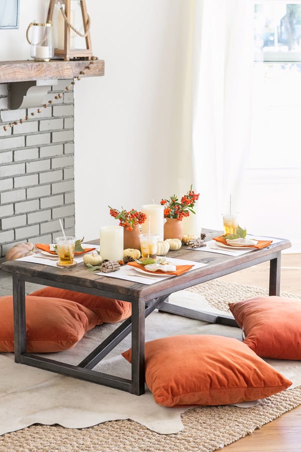 Table set with pumpkins and Thanksgiving crafts for kids. 