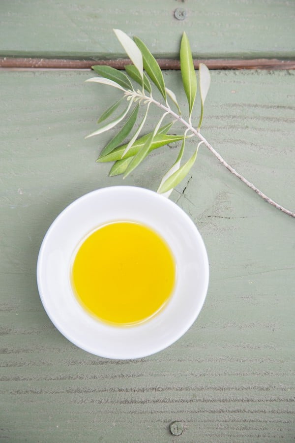 Bowl of olive oil on green table