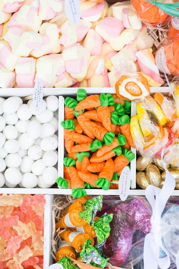 Marshmallows, gummy carrots, lollipops, chocolate eggs and chocolate carrots in a box - easter bunny