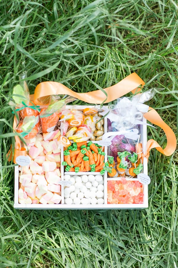 Old-fashioned candy box filled with Easter candy sitting in grass - easter eggs