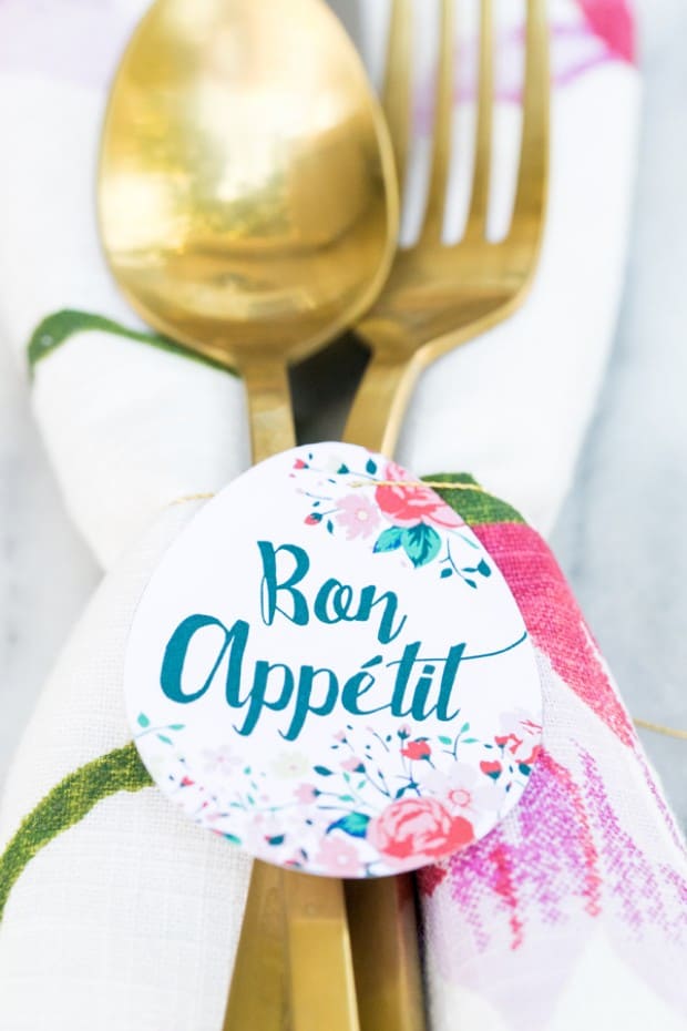 Paper egg shape printable, tied around a napkin and gold flatware. 