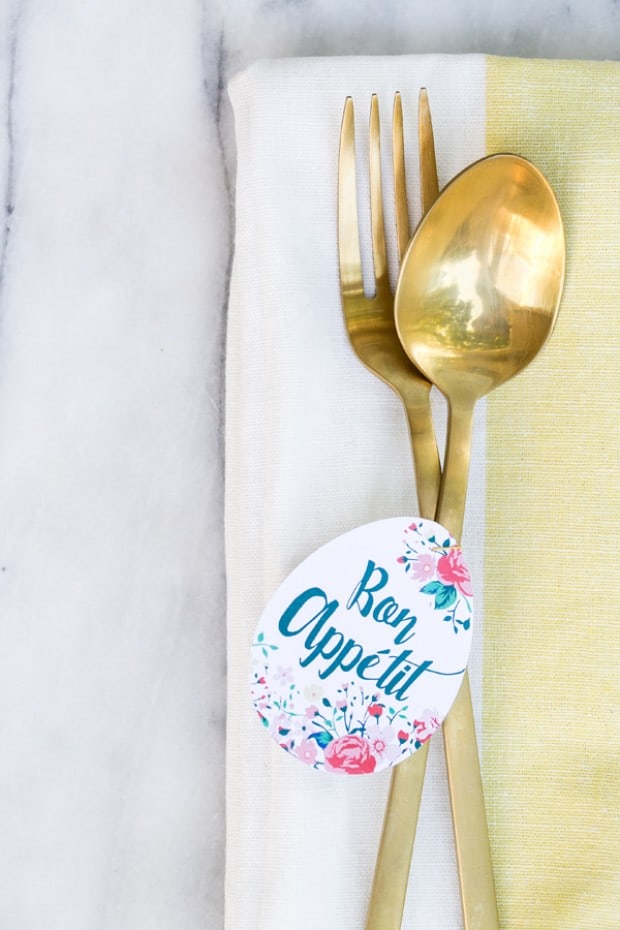 Paper egg with Bon Appetit printed on it and tied around gold flatware.
