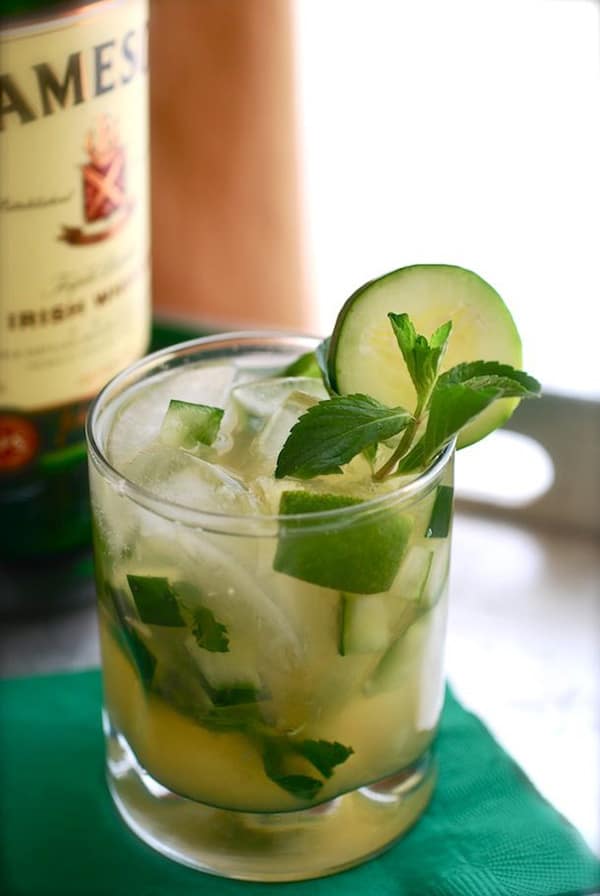 Green whiskey smash with mint in a glass and lime.