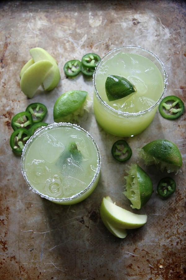 Sour green apple margaritas overhead with lemons, apples and jalapeños.