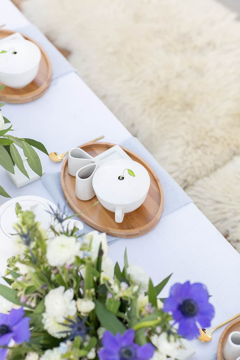 Tea setting with blue and white flowers and table linens. - tea leaves