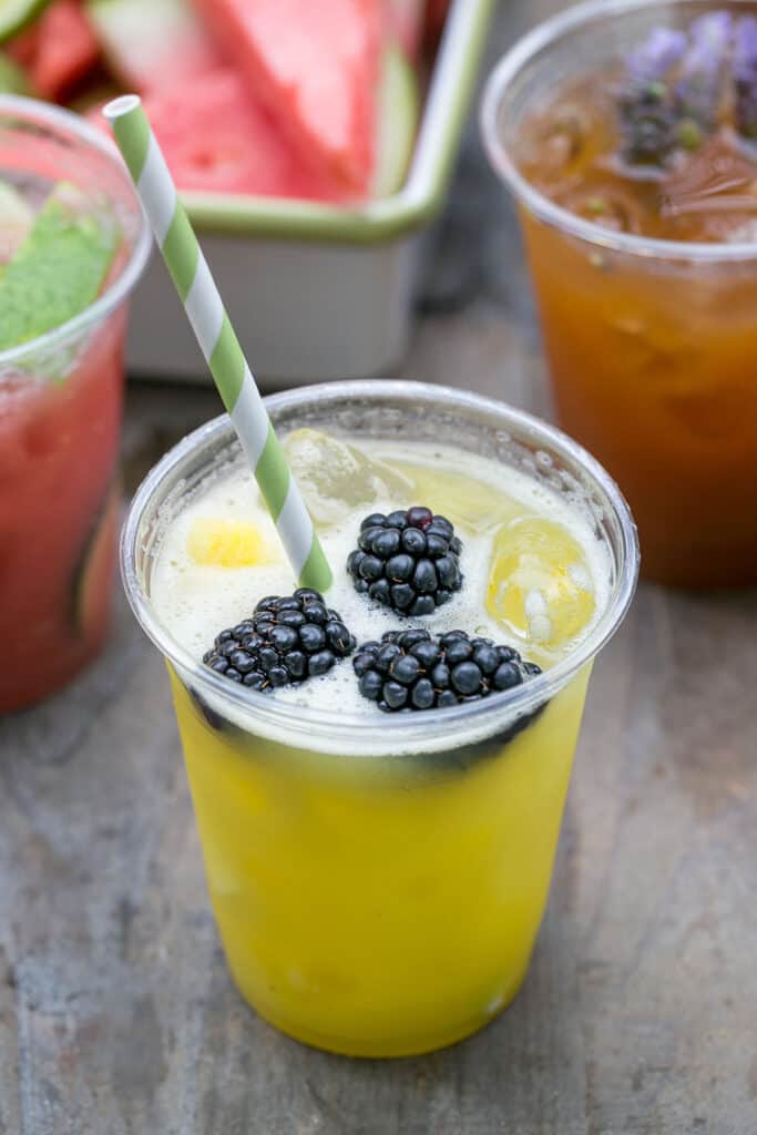 Peach and lavender agua fresca in a cup with fresh lavender garnish.