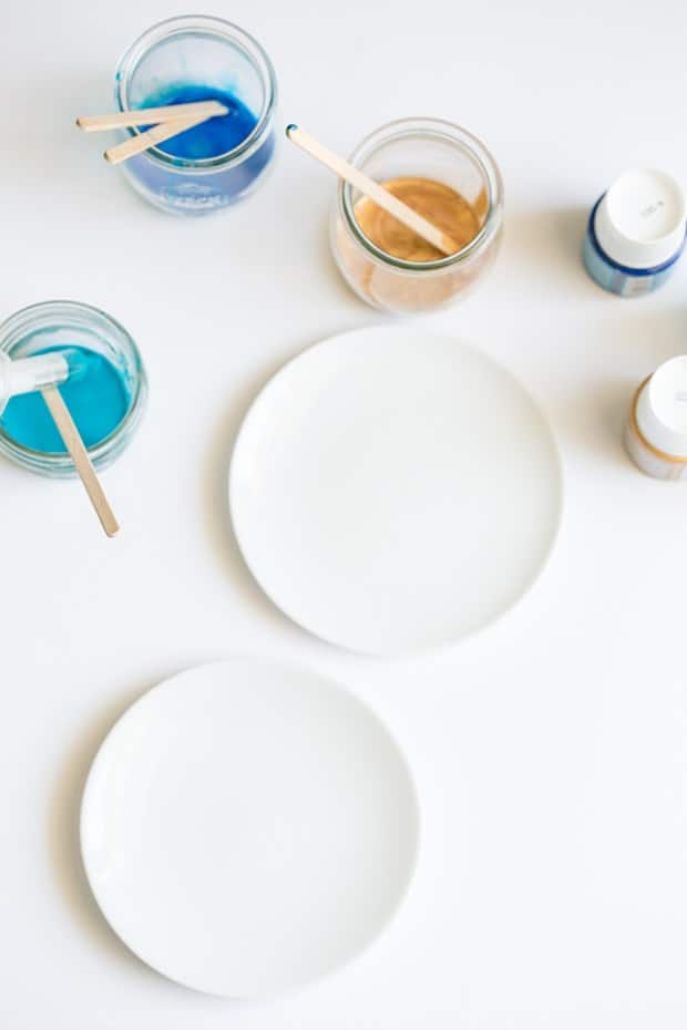 white plate with colored paint in small jars.