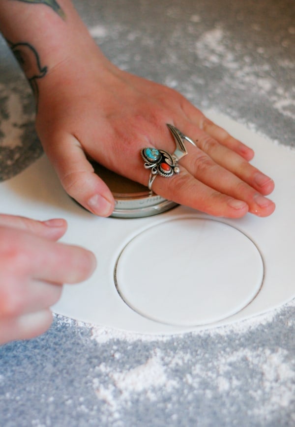 Hand pressing a cookie cutter into fondant