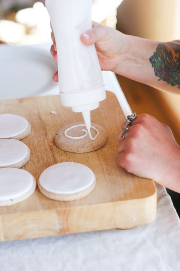 Squeezing royal icing on a cookie 