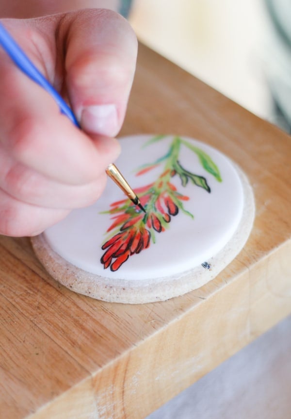 Hand painting flowers on cookies.