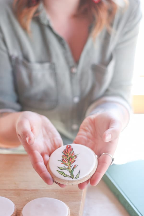 Hand painted flower on a cookie covered in fondant.