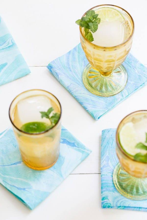 Yellow glasses sitting on blue and green marbled napkins.