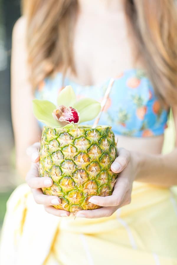 Girl holding a pineapple mojito 