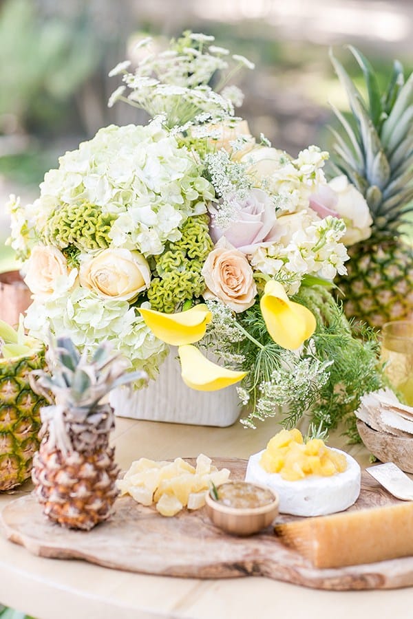 Beautiful tropical flower arrangement on a table with a baby pineapple.