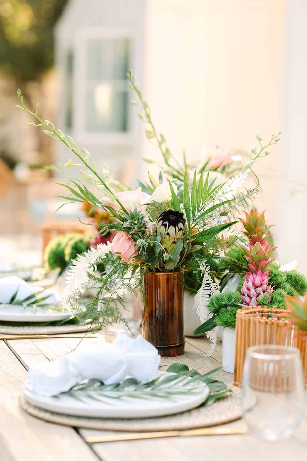Tropical birthday party with flowers and a table setting.