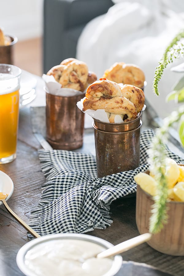 homemade pretzels in a copper cup with cheese dip and beer. 