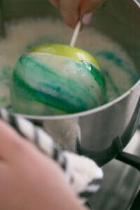 swirling a candy apple in sugar mixture