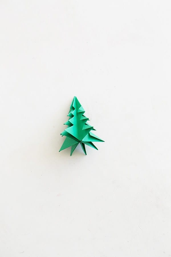 One green paper origami tree on a table. - origami christmas tree, origami paper, large trees
