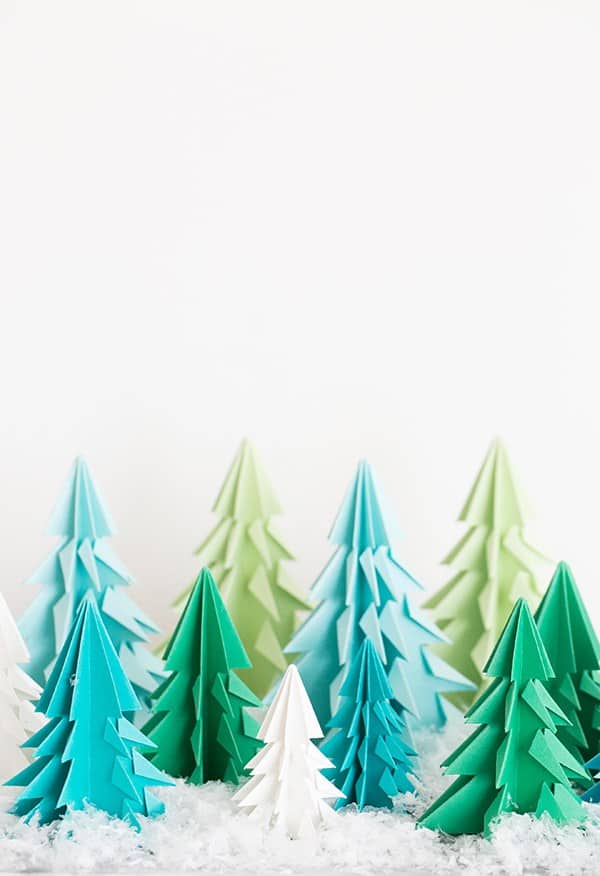 Paper origami trees on a table with fake snow. - origami christmas tree