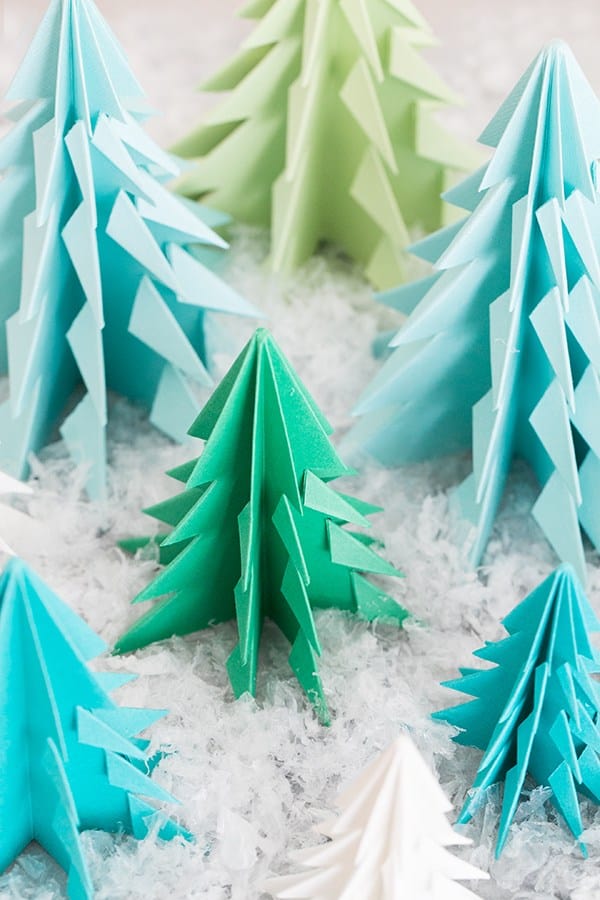 Paper origami trees on a table with fake snow.