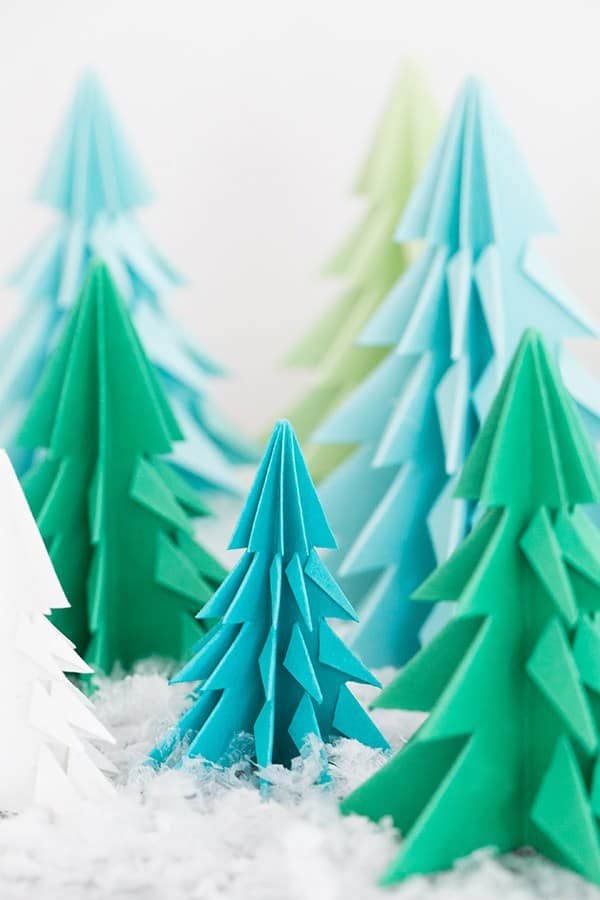 Paper origami trees on a table with fake snow. - origami christmas tree, origami paper, origami christmas, diamond shape
