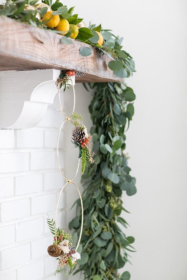 Modern gold ring wreath with flowers and pinecones 