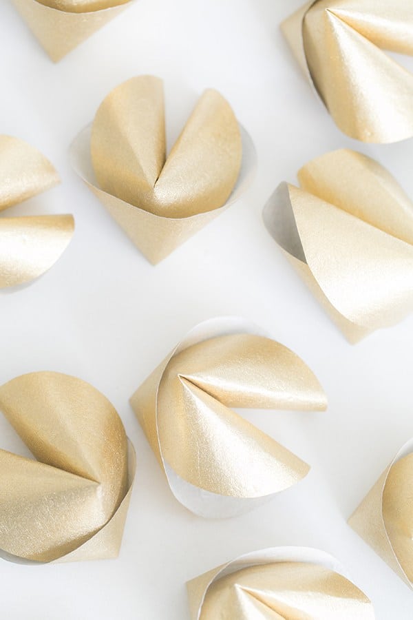 DIY gold paper fortune cookies on white table - fortune cookie shape