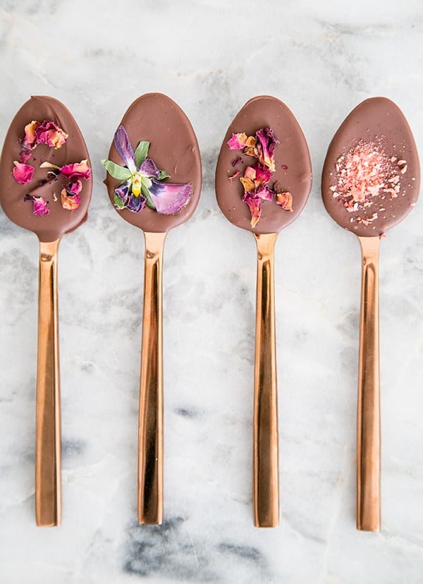 Four chocolate spoons lined together with dried flowers. - chocolate spoons, chocolate chips, hot cocoa, hot chocolate spoons, melt chocolate