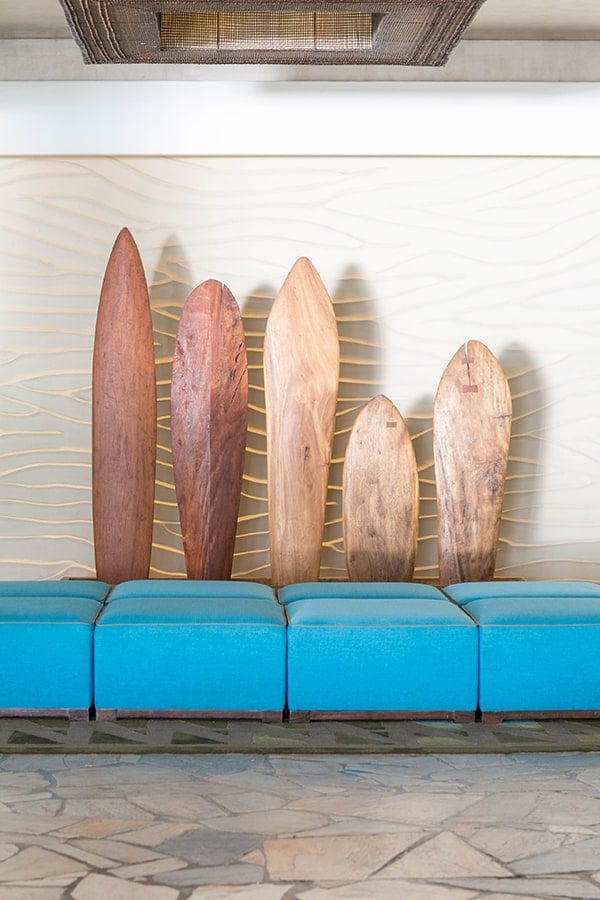 Wooden surf boards with a blue couch.