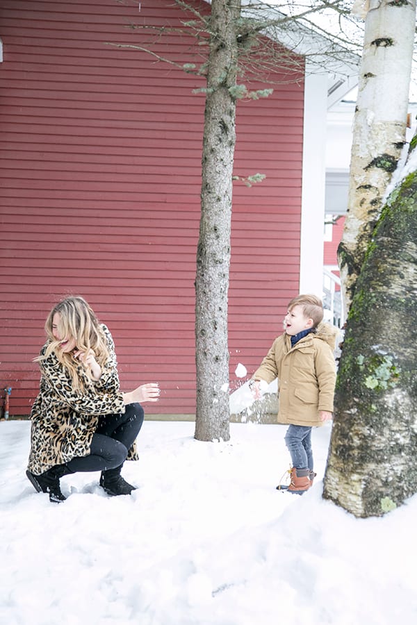 Little boy throwing snowball at mom in Stowe Vermont 
