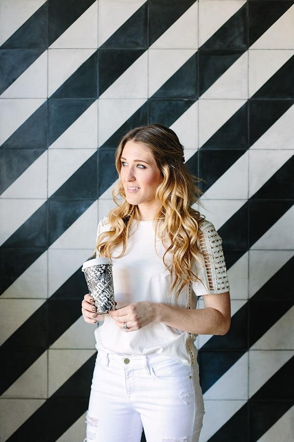 Eden Passante standing next to black and white tile at Alfred Coffee 