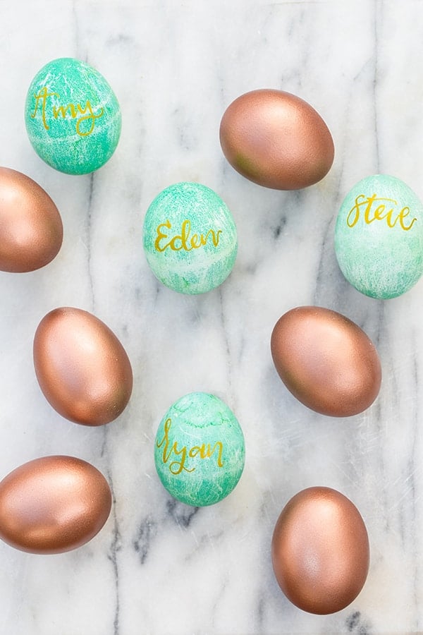 Copper Easter eggs and green dyed eggs with gold names.