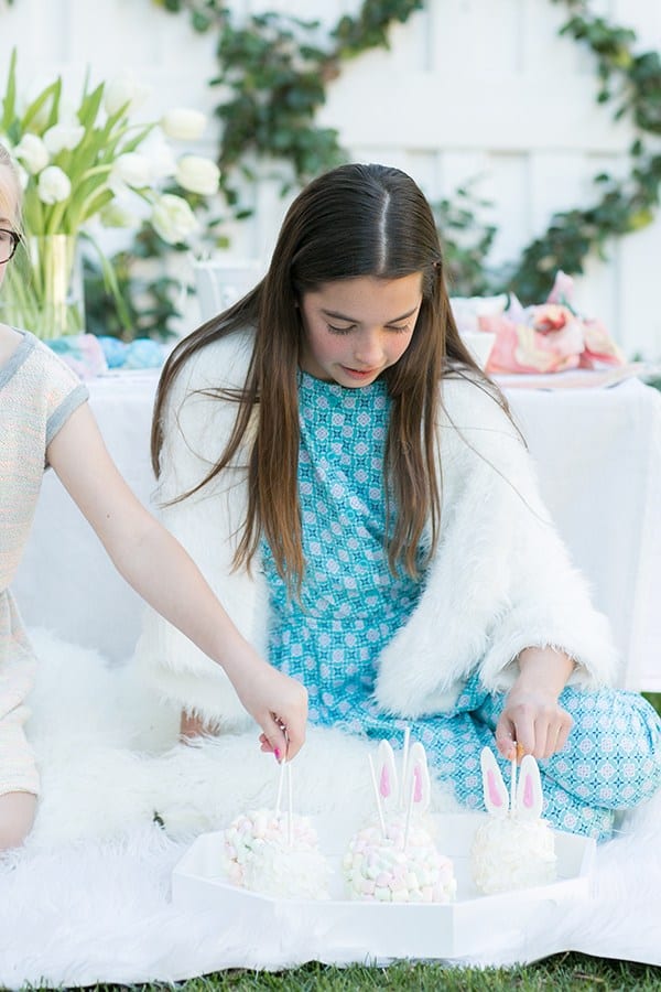 Two girls grabbing candy apples at an Easter party 