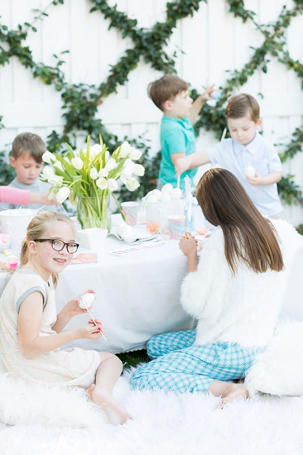 Kids sitting around a table at an Easter party decorating eggs